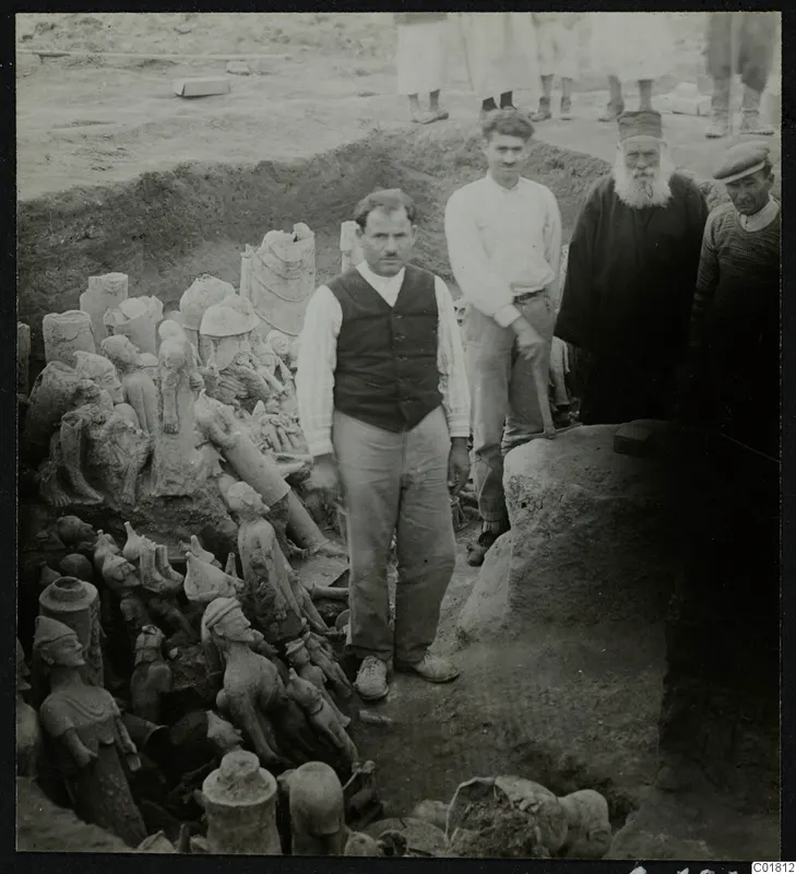 Men standing beside a trench at Ayia Irini filled with figurines and vessels laid out in the ground