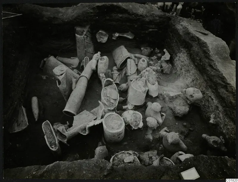 Excavation square K 10 at Ayia Irini, with pale clay vessels and figurines lying in situ in the trench.