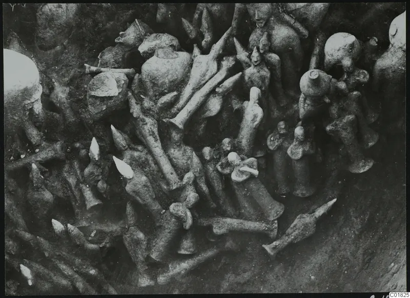 In-situ find of clay figurines packed together in soil during excavation at Ayia Irini