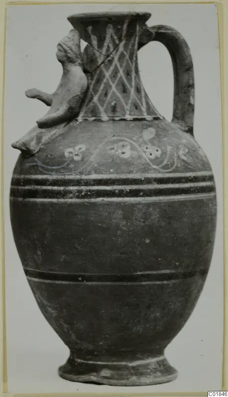 Painted jug with a modelled head on the shoulder and a loop handle, from Marion.