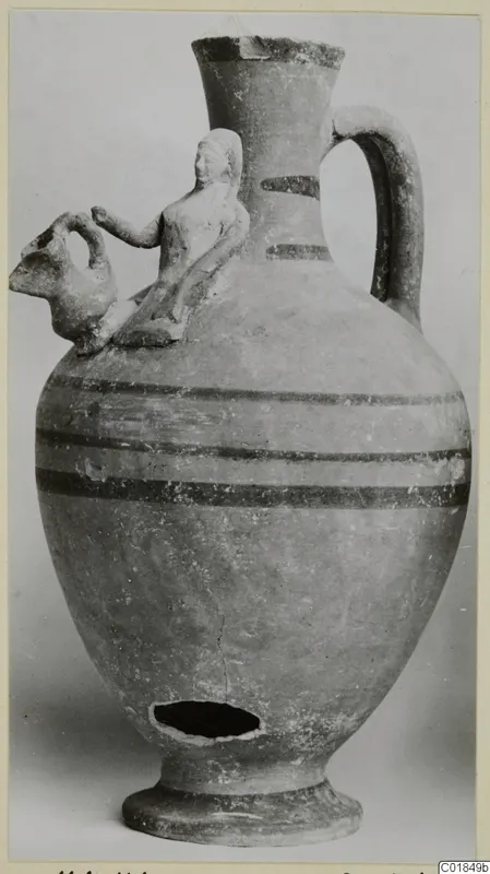 Pottery jug from Marion with a modelled figure and an animal head on the shoulder and dark painted bands