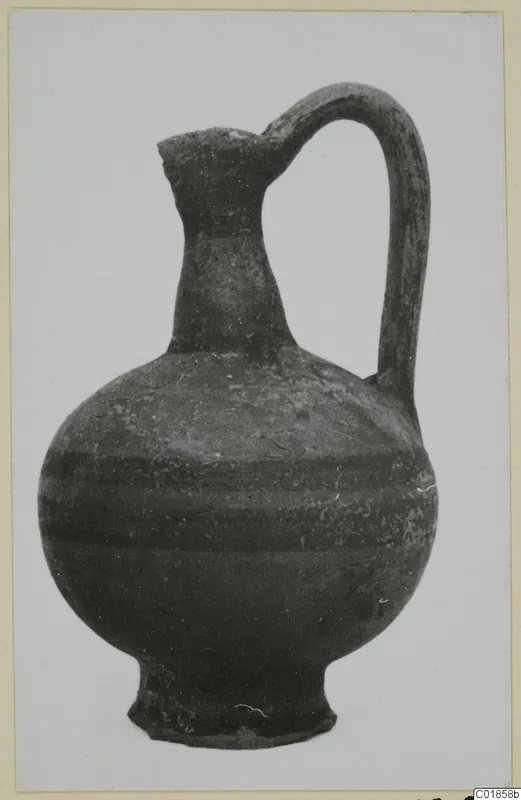 Jug with a single loop handle and a rounded body, photographed against a pale background