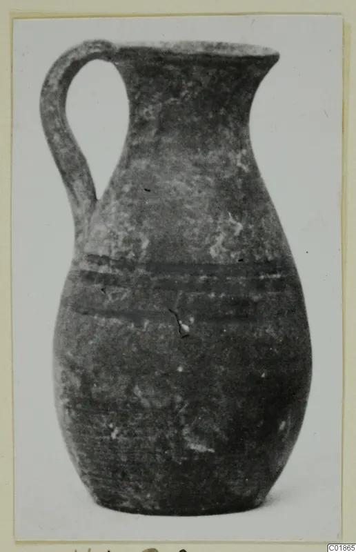 Pottery White Painted VI jug with a single loop handle and two dark bands around the body