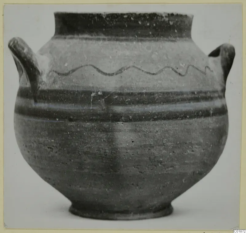 Pottery vessel from Marion with two handles and a wavy painted line on the shoulder, shown against a plain background