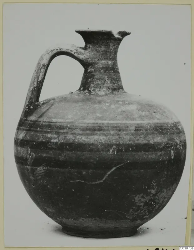 Bichrome-Red jug with one handle and dark horizontal bands, shown against a pale background