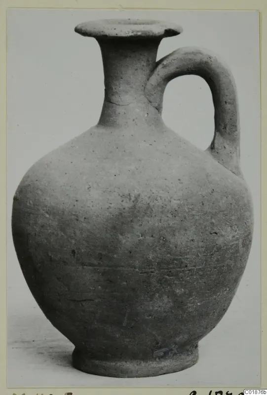 Pottery jug with a flared rim, tall neck and single loop handle, photographed against a plain background.