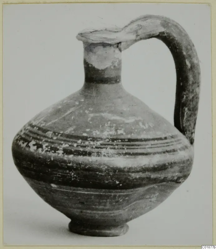 Jug from Marion in Black-on-Red II-IV, with a tall strap handle and dark painted bands on the body