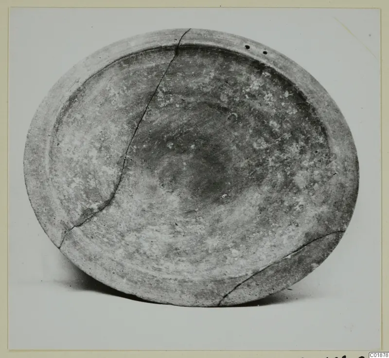Pottery bowl from Marion seen from above, cracked across its body, with two small holes near the rim.