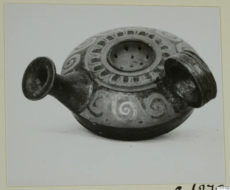 Dark pottery vessel with white spiral painting, a flared spout and a perforated disc on its top