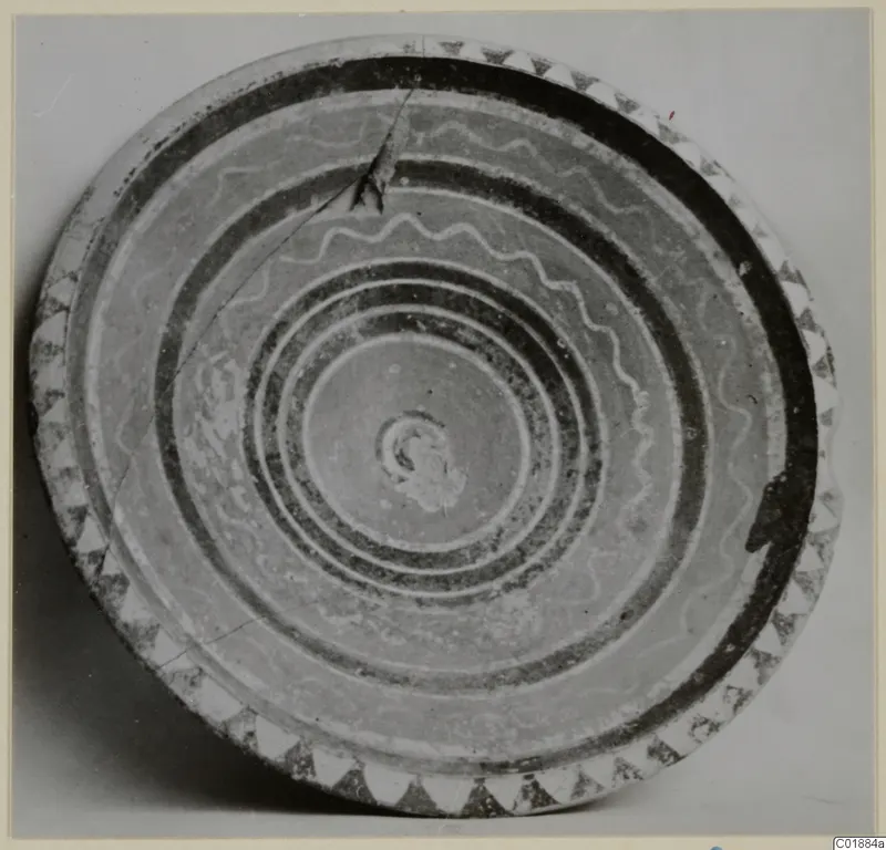 Bowl seen from above, with dark concentric bands, wavy lines across the interior and a triangle border on the rim