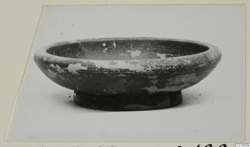 Black glazed ware bowl with a low foot, photographed on a card mount