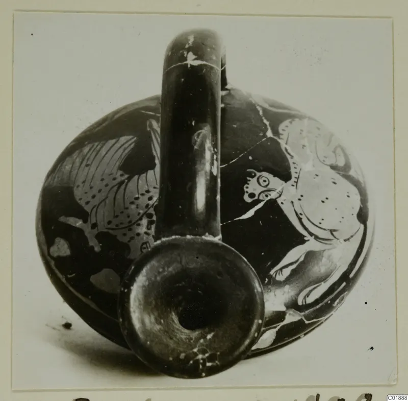 Round-bodied pottery vessel with a tall loop handle and painted figures on its body, neck opening facing the camera