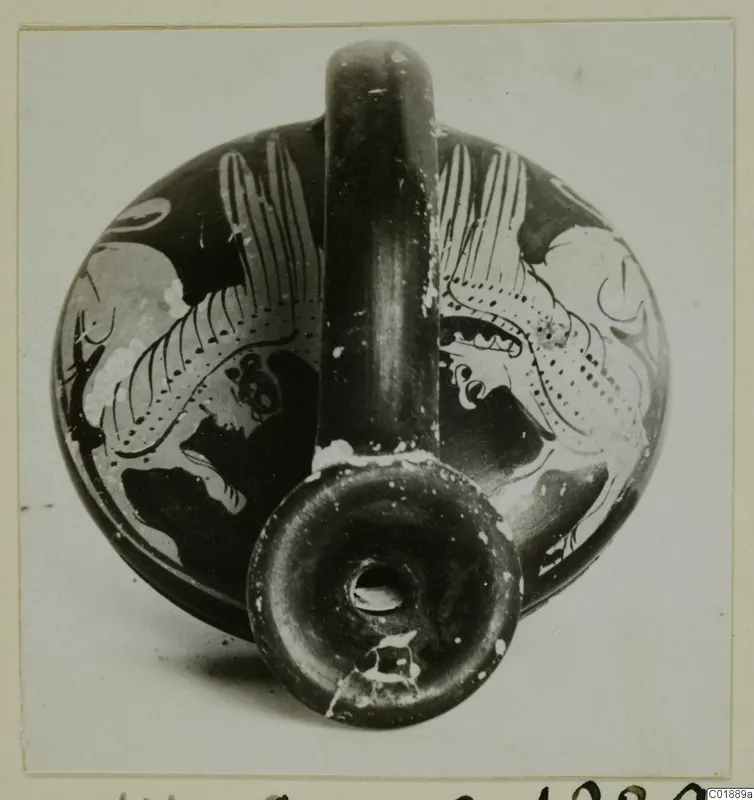 Squat painted vessel with a tall strap handle and ring foot, decorated with pale motifs on a dark ground