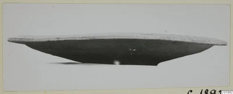 Side view of a shallow bowl, Pottery Plain White VII, with a pale rim and dark body, on a light background