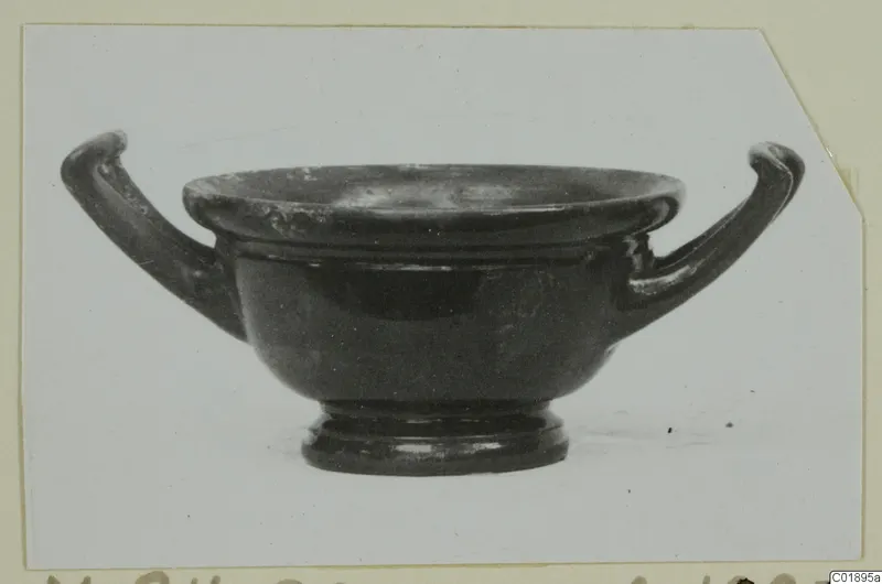Black glazed two-handled cup (kantharos) from Marion, shown in side view against a pale background