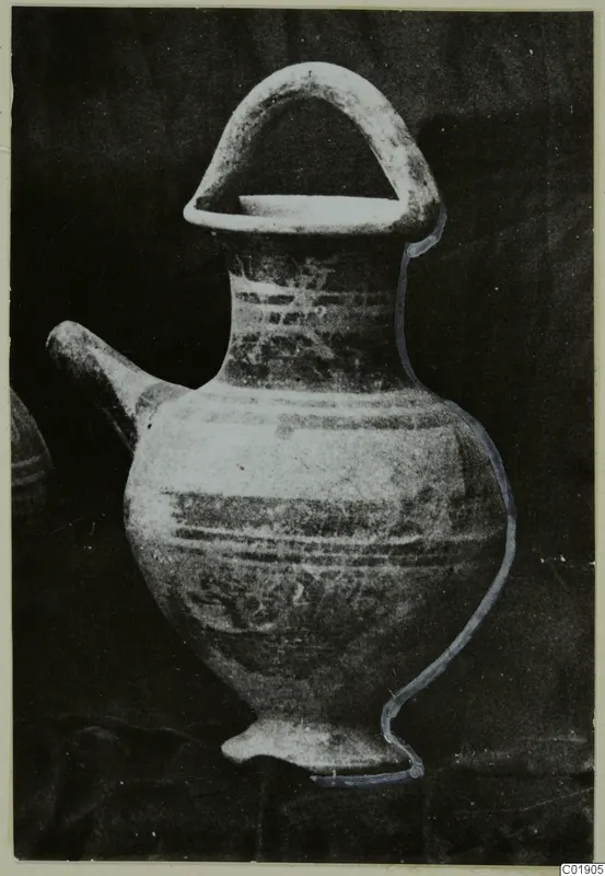 Pottery White Painted II vessel with a spout, high loop handle and painted bands, on a dark cloth