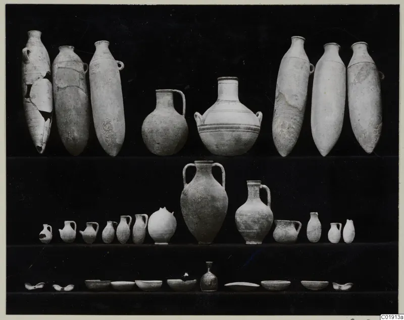 Pottery vessels from Vouni, Tomb 14, arranged in three rows on a dark background