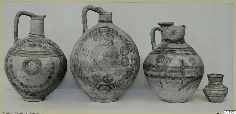 Four painted pottery vessels from Marion, Tomb 13, standing in a row against a pale backdrop.