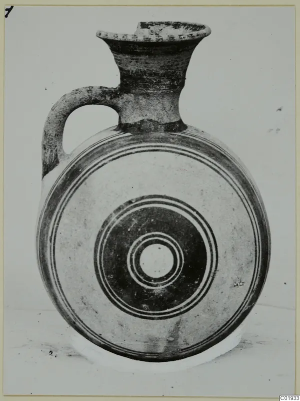 White Painted II jug from the Kastros tombs at Lapithos, with a flattened disc-shaped body and concentric painted circles
