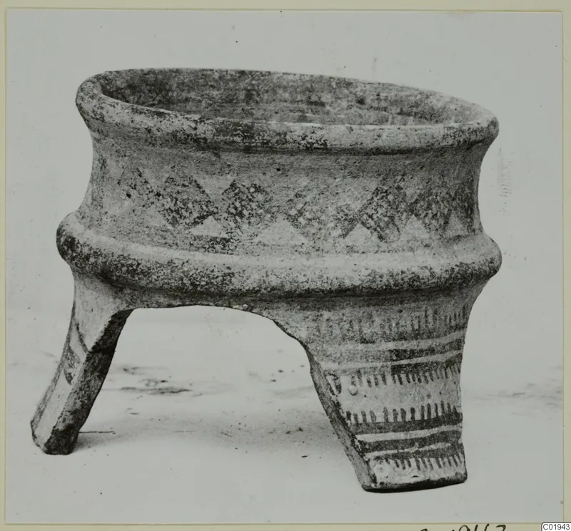 Pottery White Painted I vessel on three legs, with painted triangle motifs and bands, photographed against a plain background.