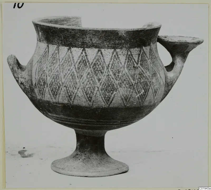 Pottery White Painted I bowl with a lozenge pattern, two handles and a footed base, seen from the side.