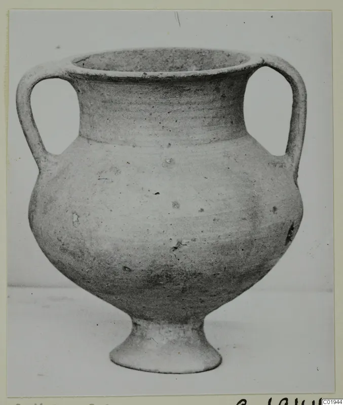 Pottery amphoriskos with two handles and a ring foot, shown against a plain background.
