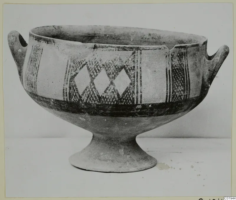 White Painted I bowl with two side handles and a footed base, decorated with lozenges and vertical bands