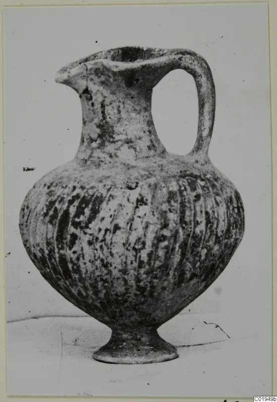 Pottery jug, Black Slip I-VI, with a strap handle, vertical fluting and a pedestal foot