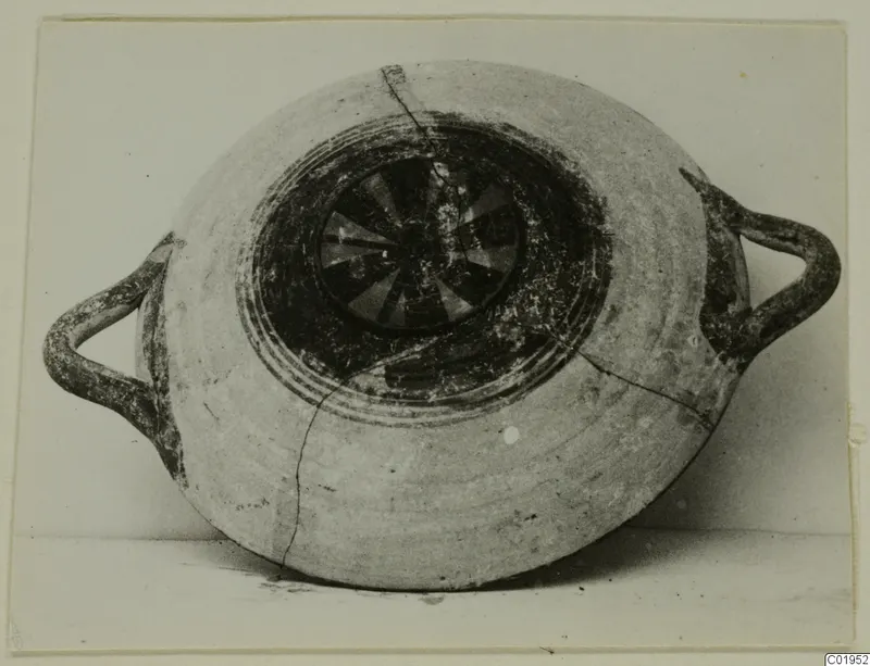 Two-handled pottery vessel from Lapithos, seen from above, with dark painted concentric rings and a radiating pattern in the centre.