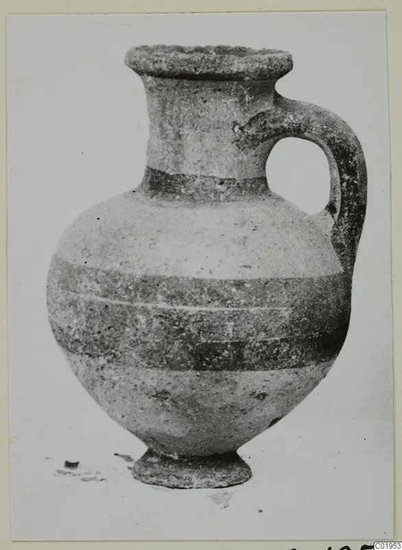 Pottery Bichrome II jug from Lapithos, with a single loop handle and dark horizontal bands on its body