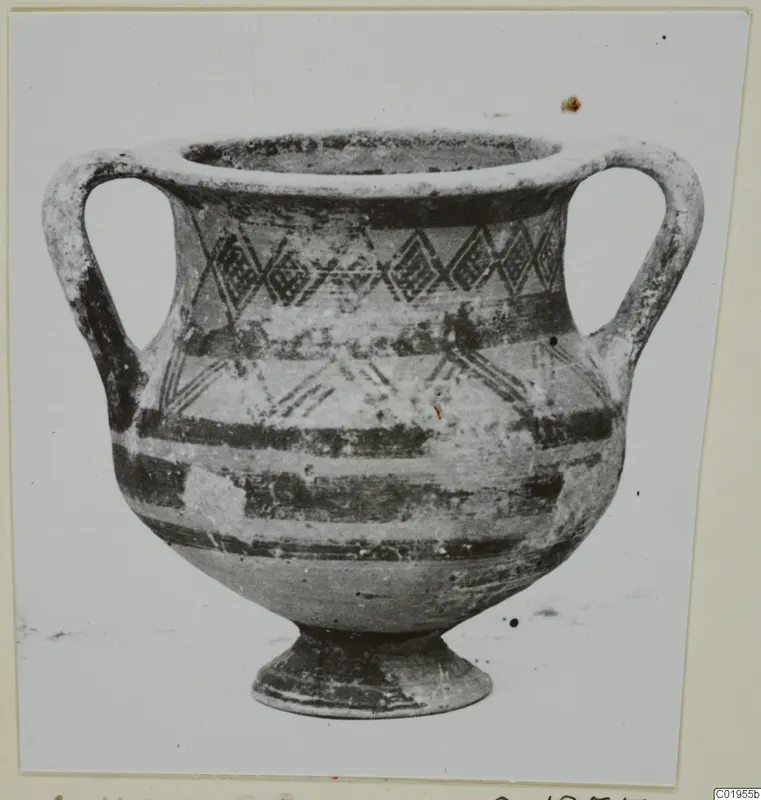 Two-handled pottery vessel with dark painted bands and diamond-shaped motifs on the body, on a short foot