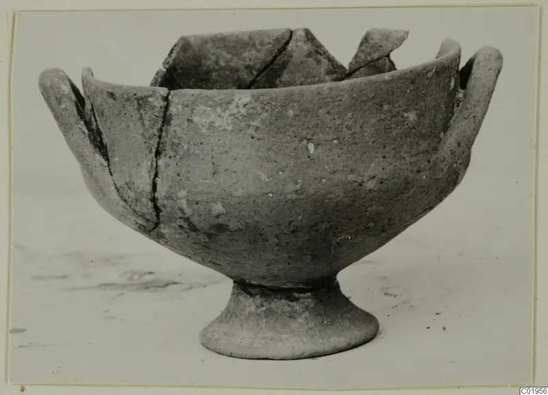 Pottery White Painted I bowl from Lapithos, with a footed base, two handles and a broken rim with sherds at the back.