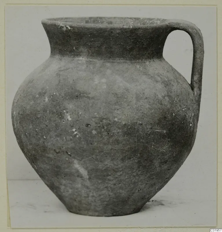 Pottery Coarse Ware jug with a single loop handle and a wide mouth, shown against a plain background