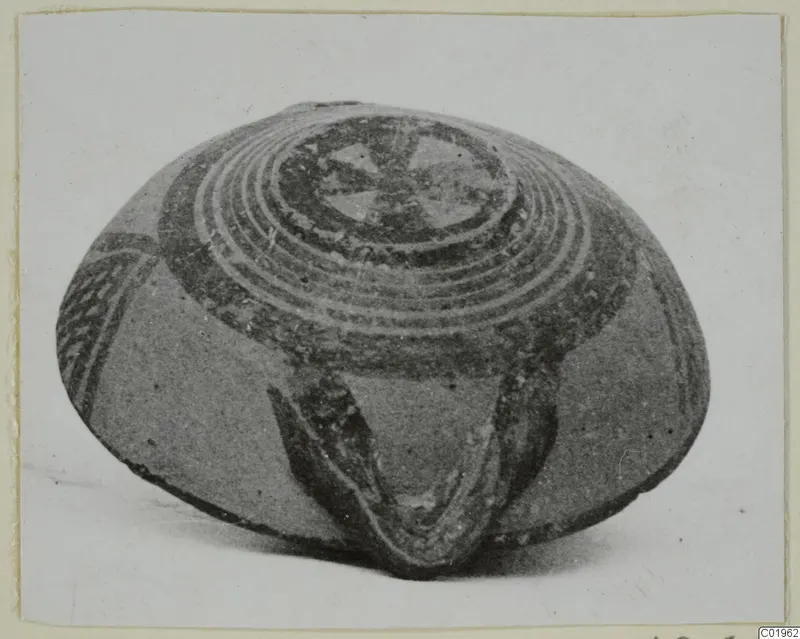 White Painted I bowl, photographed at an angle, with concentric rings and a central motif on its upper surface