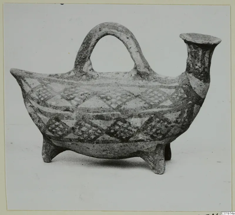 Pottery White Painted I vessel with a loop handle, spout and three legs, decorated with bands and diamond patterns.
