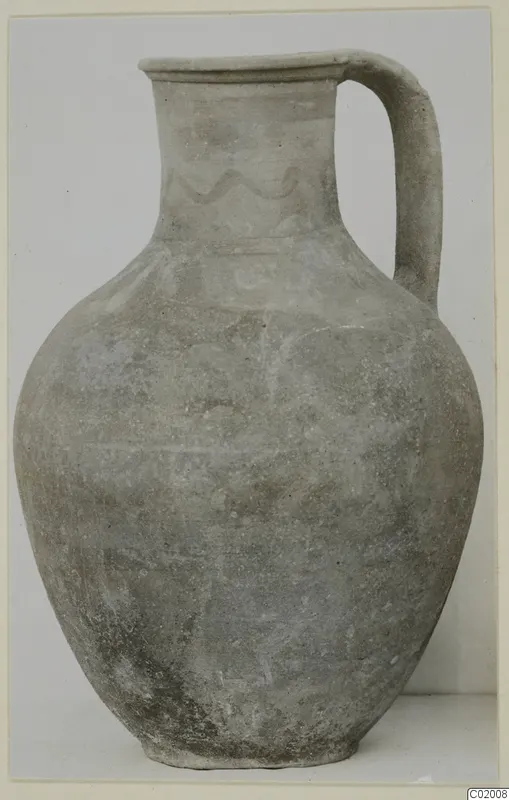 Pottery jug, White Painted VII, with a single strap handle and a faded wavy painted band on the neck