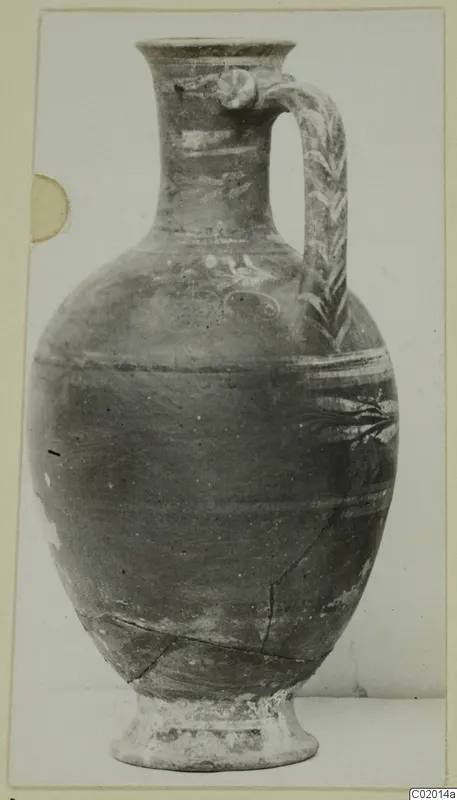 Bichrome-Red pottery jug with a strap handle and painted bands, photographed against a plain background