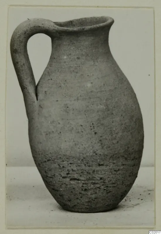Pottery Plain White VI juglet with a single loop handle and a flaring rim