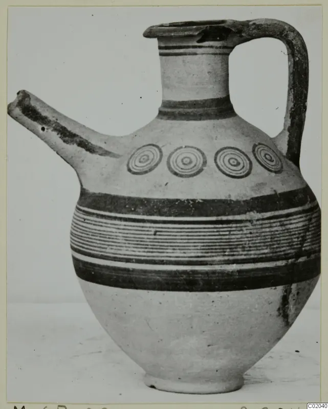 White Painted IV juglet with a long spout, strap handle, concentric circles and horizontal painted bands