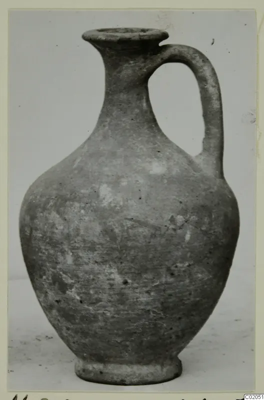 Cypro-Hell.I. pottery jug with a single loop handle, photographed against a pale background
