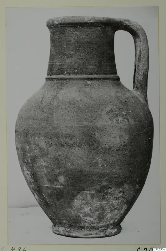 Single-handled jug with a tall neck and rounded body, photographed against a pale background.