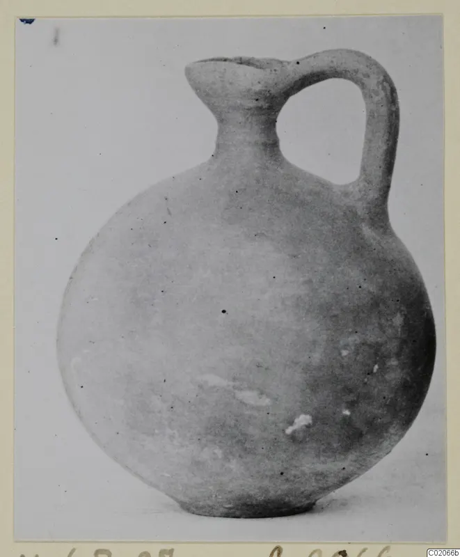 Round-bodied jug with a single loop handle and a flared mouth, a find from Marion photographed on a plain background