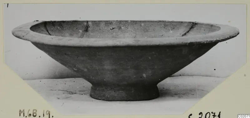 Pottery Plain White IV-V bowl with flaring sides, a thick rim and a short ring foot, seen from the side.