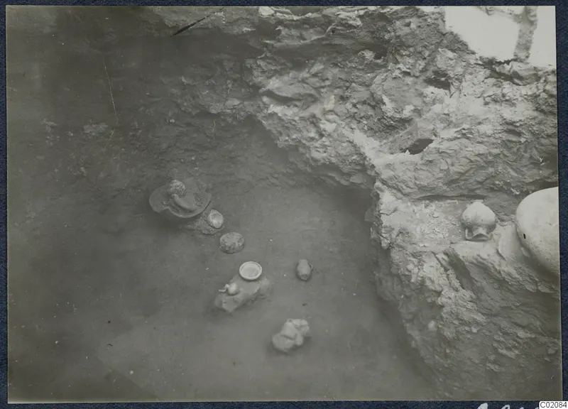 Pots and a small bowl lying on the floor of an excavated area at Marion