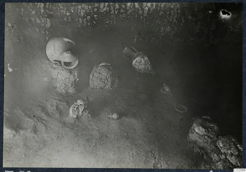 Tomb 72 at Marion during excavation, with pottery vessels lying on the sandy floor of the chamber.