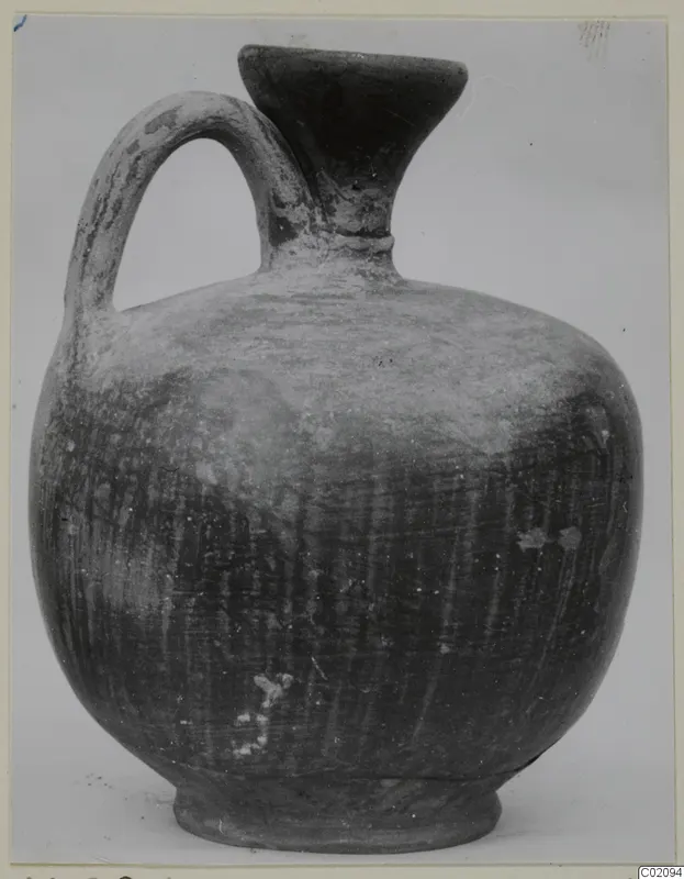 Jug of Stroke Polished Ware with a single loop handle and a flared mouth, shown against a plain background