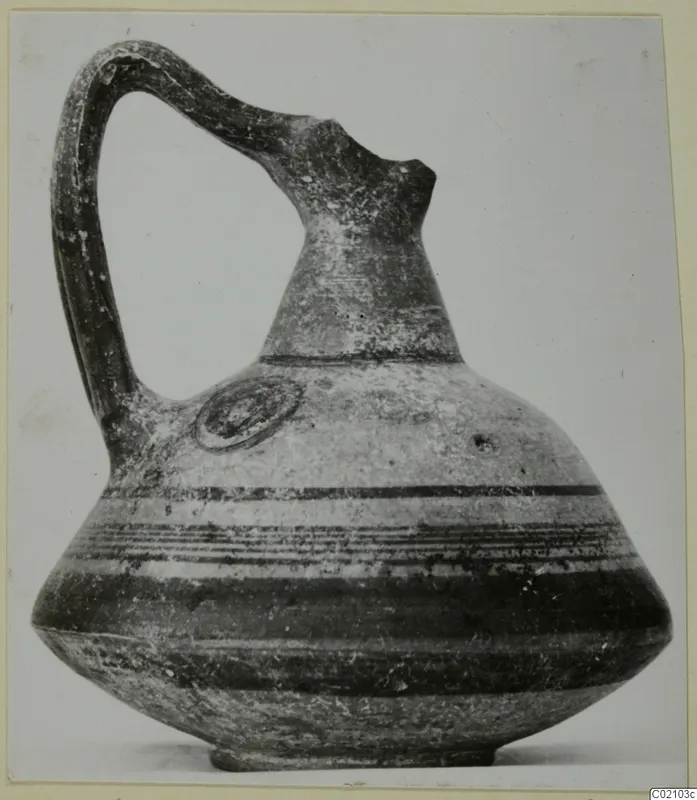 Pottery Black-on-Red II-IV jug with a tall neck, strap handle and horizontal dark bands on the body