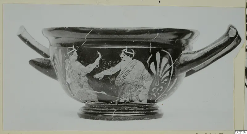 Two-handled skyphos with two painted figures and a palmette ornament, photographed on a mount.