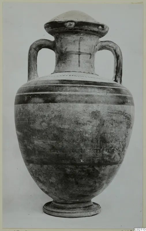 Two-handled pottery jar with a domed lid, dark painted bands on the body and a cross-shaped mark on the neck
