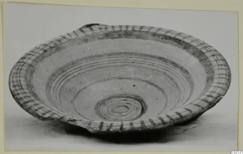 Shallow painted plate or bowl from Marion, with concentric dark bands and a cross-hatched rim